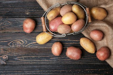 Sepeti ahşap masa, üstten görünüm üzerinde taze Çiğ patates ile