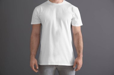 Şık beyaz t-shirt gri arka plan üzerine yakışıklı genç adam. Mockup tasarım için