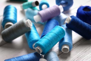 Ahşap arka plan üzerinde renkli dikiş ipliği kümesi