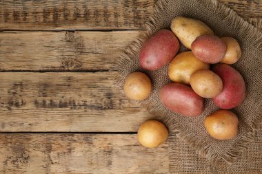 Ahşap arka planda taze çiğ patates, üst manzara.