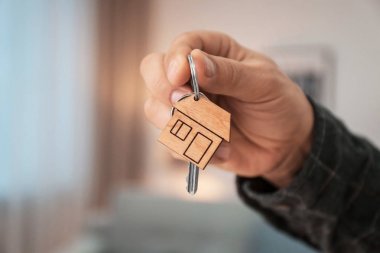 Bulanık arka planda, closeup evin anahtarı tutan adam