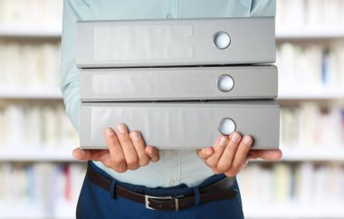 Arşiv klasörleri belgelerle yığını tutan adam