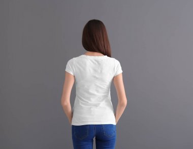 Şık beyaz t-shirt gri arka plan üzerine güzel genç kadın. Mockup tasarım için