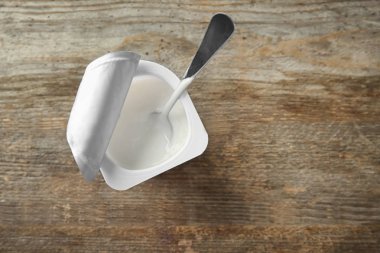 Ahşap zemin üzerine Yoğurtlu plastik bardak