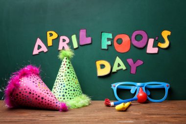 Parti kapaklar, gözlük ve boynuzları yakınındaki April fools gün ifade ile kara tahta masada