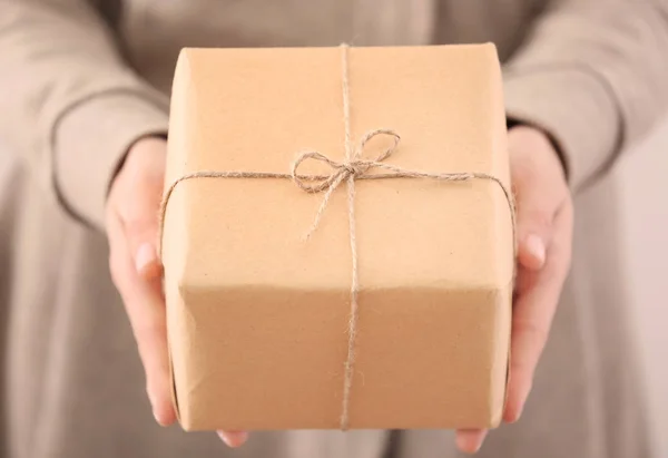 Mujer sosteniendo paquete caja de regalo, primer plano — Foto de Stock