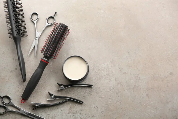 Strumenti professionali da parrucchiere e argilla per capelli su sfondo grigio — Foto Stock