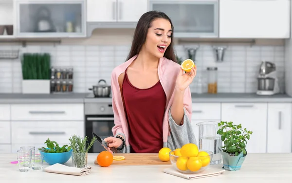 Młoda kobieta przygotowuje pyszne lemoniady w kuchni — Zdjęcie stockowe