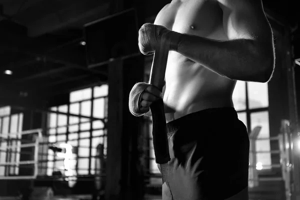 Boxer tillämpar hand wraps samtidigt förbereda sig för träning i gymmet — Stockfoto