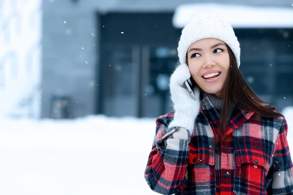 Красивая молодая женщина разговаривает по мобильному телефону на улице в зимний день — стоковое фото