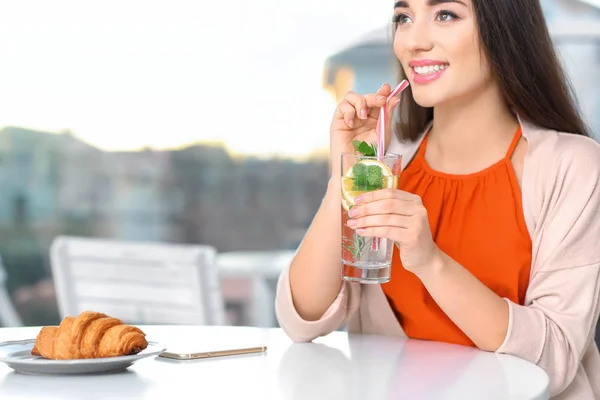 Mujer joven con vaso de limonada en la cafetería — Foto de Stock