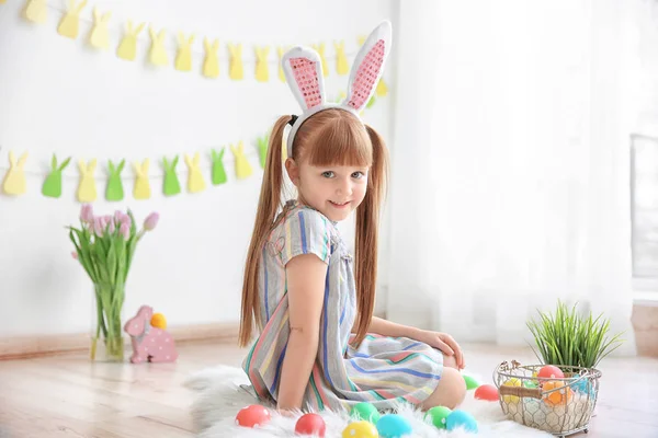 Menina bonito com orelhas de coelho dentro de casa. Caça ao ovo de Páscoa — Fotografia de Stock