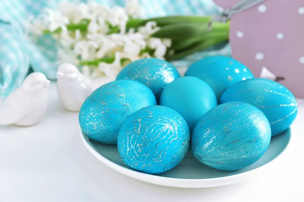 Piatto con uova di Pasqua tinte sul tavolo — Foto Stock