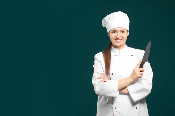 Prachtige vrouwelijke chef-kok met mes op kleur achtergrond — Stockfoto