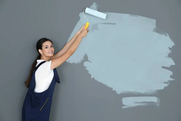 Decorator painting grey wall with roller — Stock Photo, Image