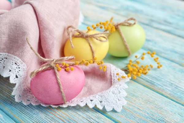 Easter eggs with mimosa flowers on table — Stock Photo, Image