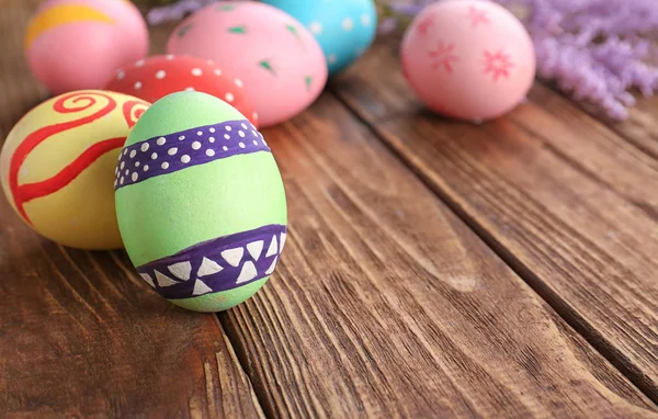 Uova di Pasqua decorate su sfondo di legno — Foto Stock