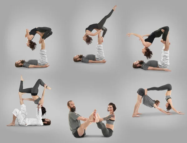 一组年轻夫妇在灰色背景下练习瑜伽 — 图库照片