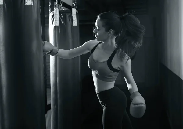 Vrouw training aan de bokszak in boksen sportschool — Stockfoto