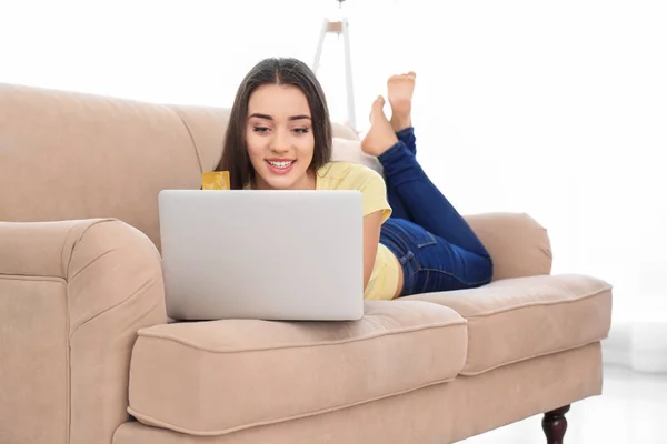 Mujer joven de compras en línea con tarjeta de crédito y portátil en casa —  Fotos de Stock