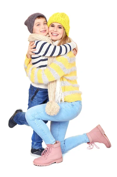 Cute little boy with mother in warm clothing on white background. Ready for winter vacation — Stock Photo, Image