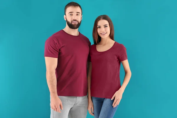 रंग पृष्ठभूमि पर स्टाइलिश टी-शर्ट में युवा आदमी और महिला। डिजाइन के लिए मोकअप — स्टॉक फ़ोटो, इमेज