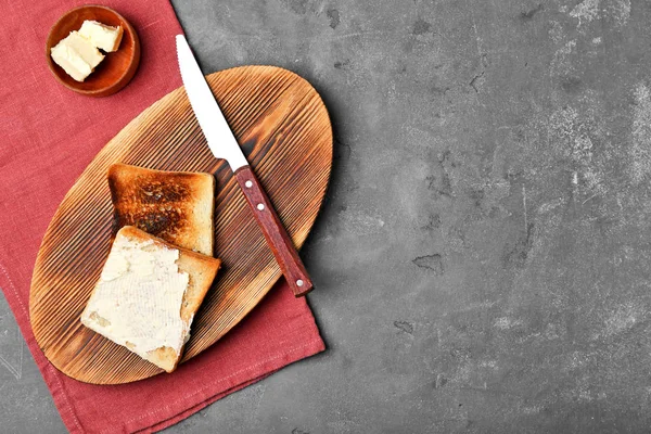 Placa de madeira com pão torrado na mesa — Fotografia de Stock