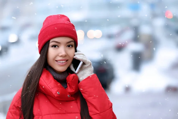 Красивая молодая женщина разговаривает по мобильному телефону на улице в зимний день — стоковое фото