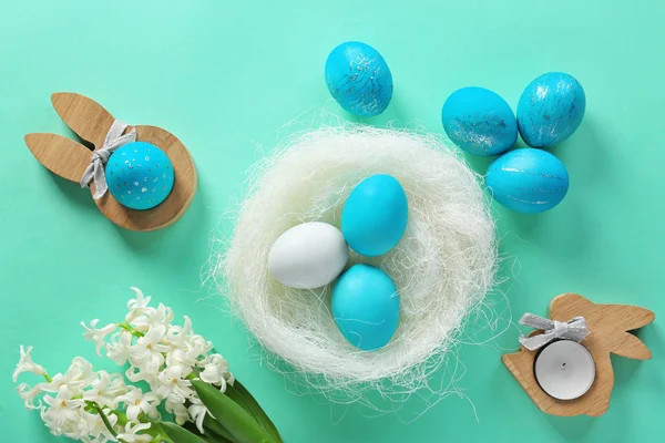Ninho decorativo com ovos de Páscoa tingidos na mesa — Fotografia de Stock