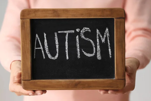 Mulher segurando quadro com a palavra "autismo", close-up — Fotografia de Stock