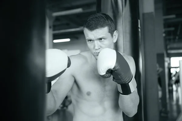 Entrenamiento de boxeador con saco de boxeo en gimnasio — Foto de Stock