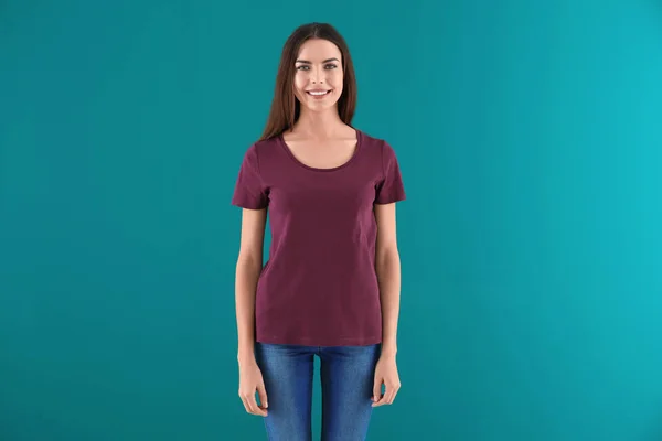 Bella giovane donna in elegante t-shirt su sfondo a colori. Mockup per il design — Foto Stock