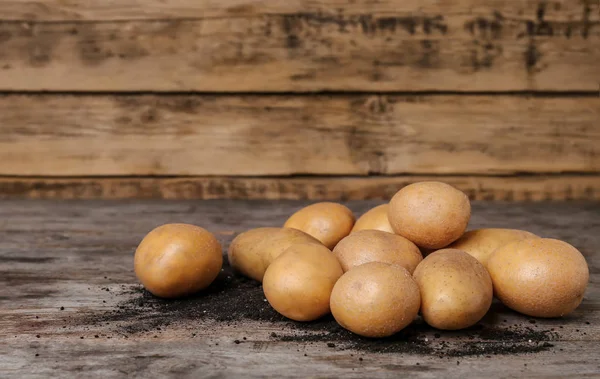 木のテーブルの上で新鮮な生ジャガイモ — ストック写真