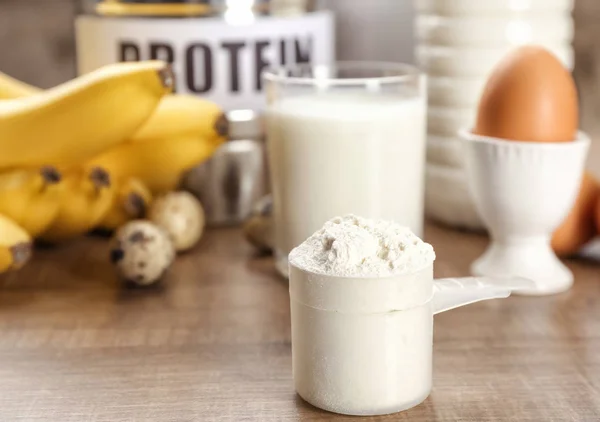 Scoop med proteinpulver og produkter på bordet - Stock-foto