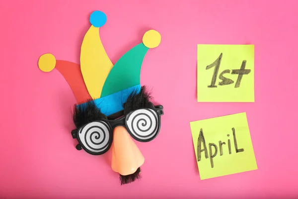 Notatki z frazę "1 kwietnia" i śmieszne okulary na kolor tła. Fool's day skład — Zdjęcie stockowe