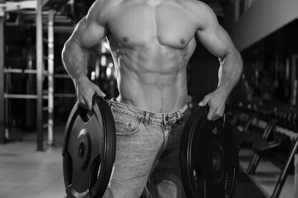Entrenamiento muscular joven culturista en gimnasio, efecto blanco y negro — Foto de Stock
