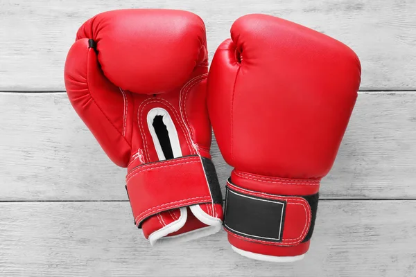 Boxerské rukavice na dřevěné pozadí — Stock fotografie