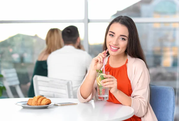 Jeune femme avec verre de limonade au café — Photo