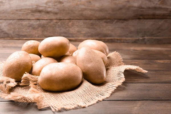 Frische rohe Kartoffeln auf Holztisch — Stockfoto