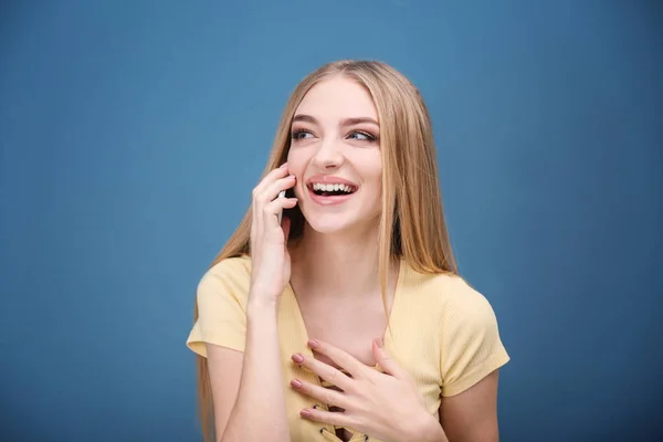 Mujer joven hablando en el teléfono celular contra el fondo de color — Foto de Stock