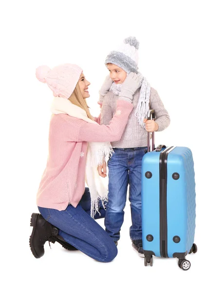 Menino bonito com mãe e bagagem no fundo branco. Pronto para férias de inverno — Fotografia de Stock