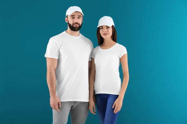 Junge Männer und Frauen in stilvollen weißen T-Shirts auf farbigem Hintergrund. Design-Attrappe — Stockfoto