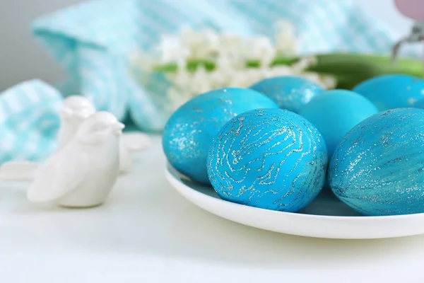 Piatto con uova di Pasqua tinte sul tavolo — Foto Stock