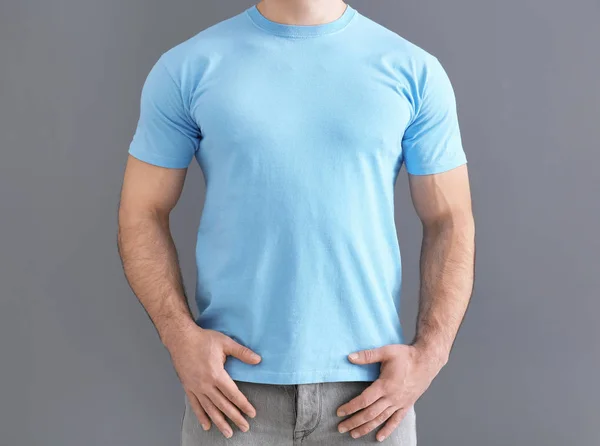 Bonito jovem em elegante t-shirt em fundo cinza. Mockup para design — Fotografia de Stock