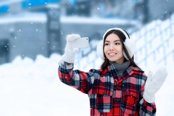美丽的年轻女子在冬日自拍带手机外出 — 图库照片