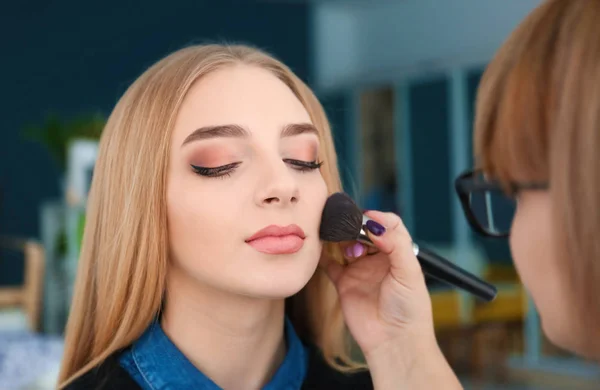 Professionele visage kunstenaar toepassing van make-up op vrouw gezicht achter de schermen — Stockfoto