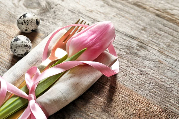 Prachtig ingericht bestek en tulip bloem voor instelling van de tabel van de Pasen op houten achtergrond — Stockfoto