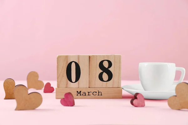 Wooden block calendar and cup of coffee on table. International Women's Day celebration — Stock Photo, Image