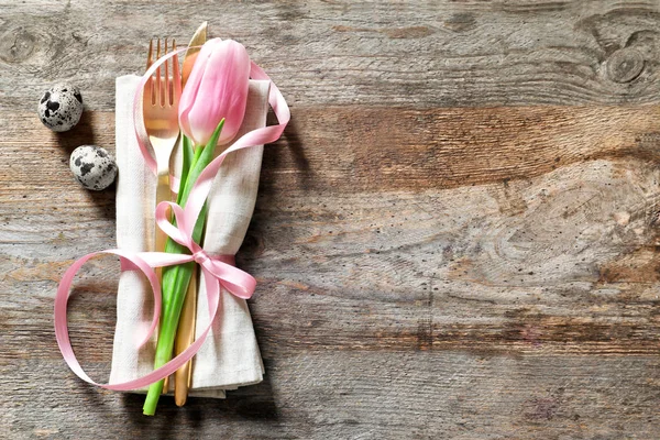 Çatal bıçak takımı ve ahşap arka plan Paskalya Tablo ayarı için Lale çiçek güzel dekore edilmiş