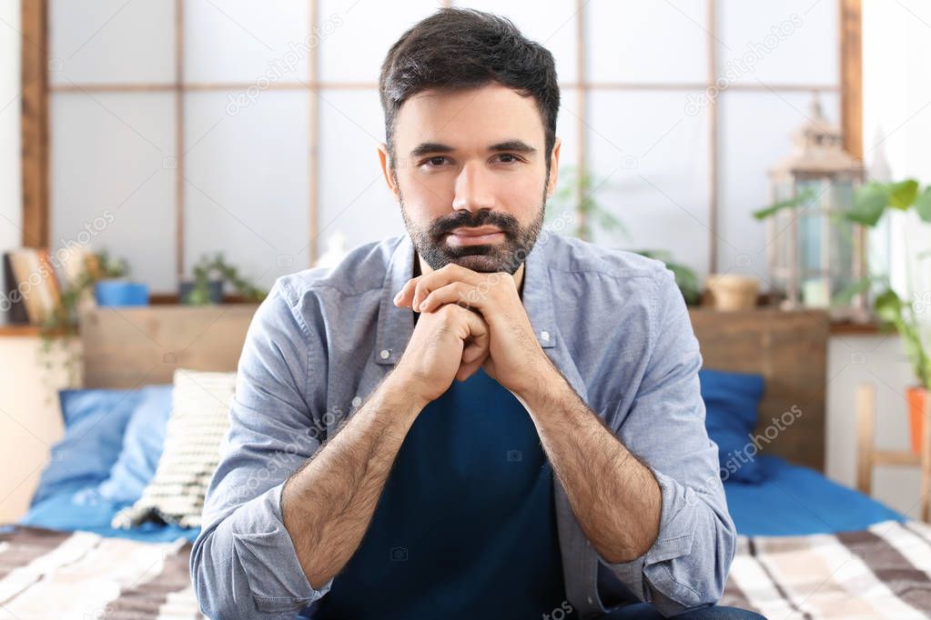 Young bearded man in casual clothes indoors